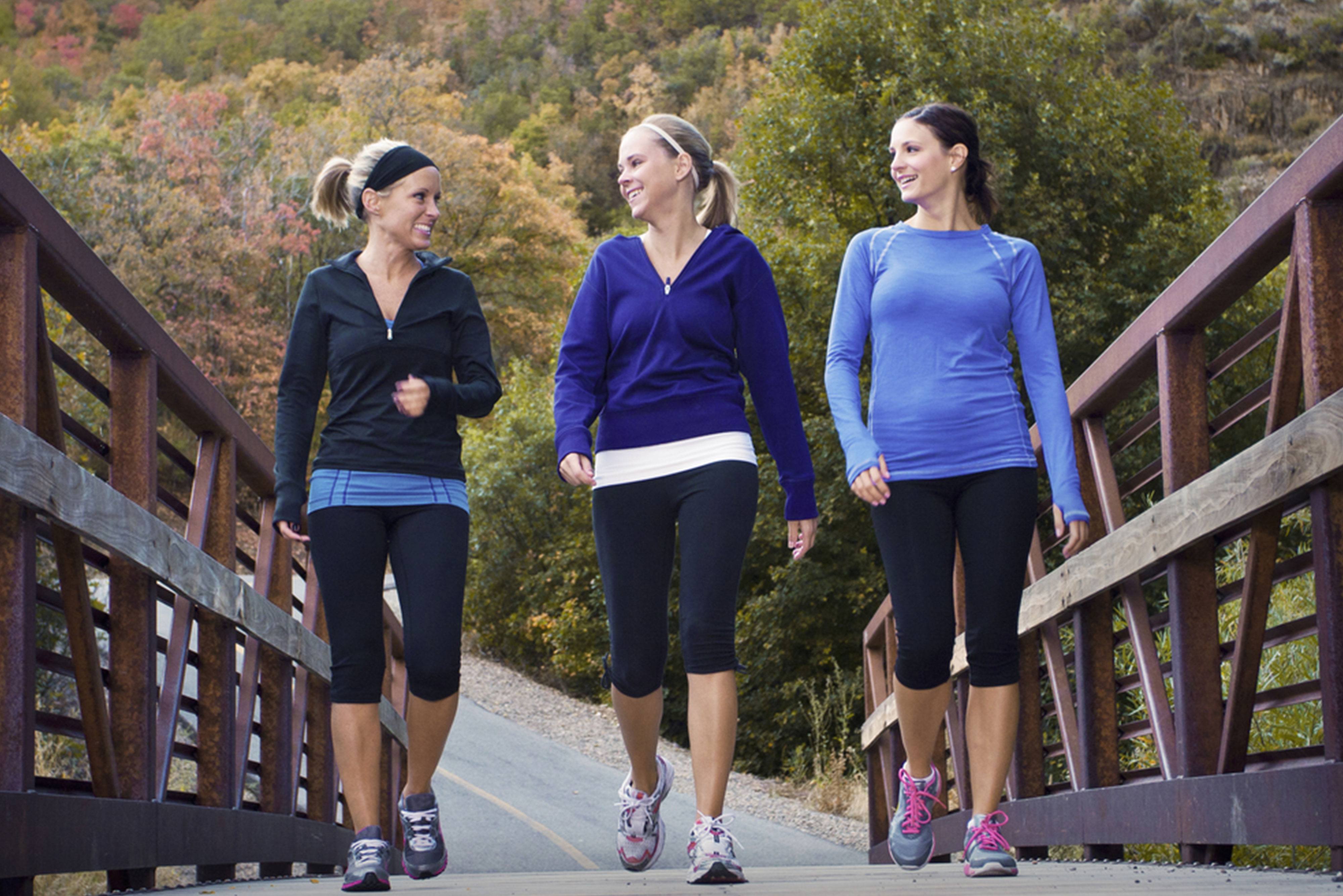 3 women walking across a bridge on a jog
