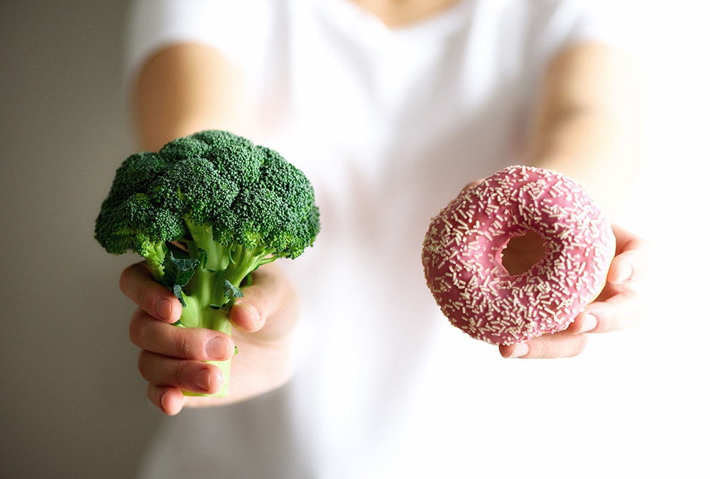 person holding broccoli and donuts together