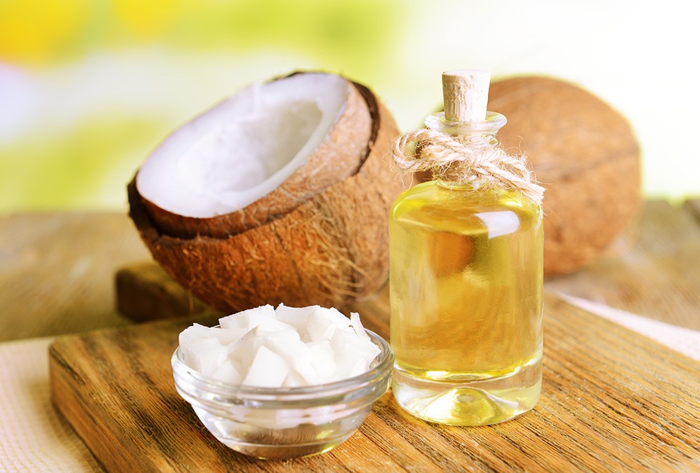bottle of mct oil and coconuts halves and coconut meat