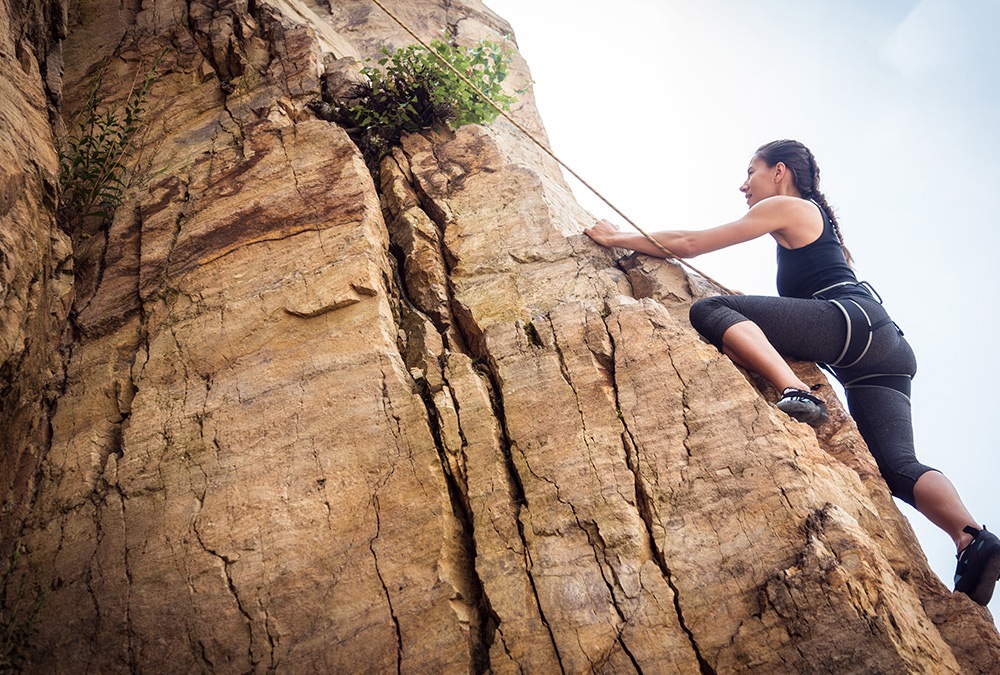 lady rock climbing without helmet