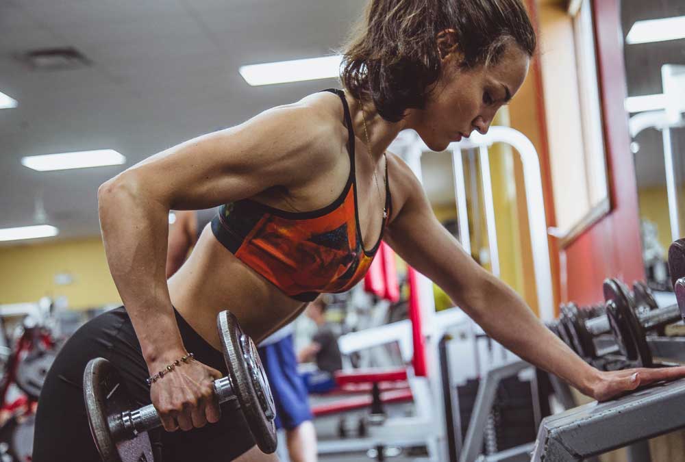 woman lifting dumbbell at the gym
