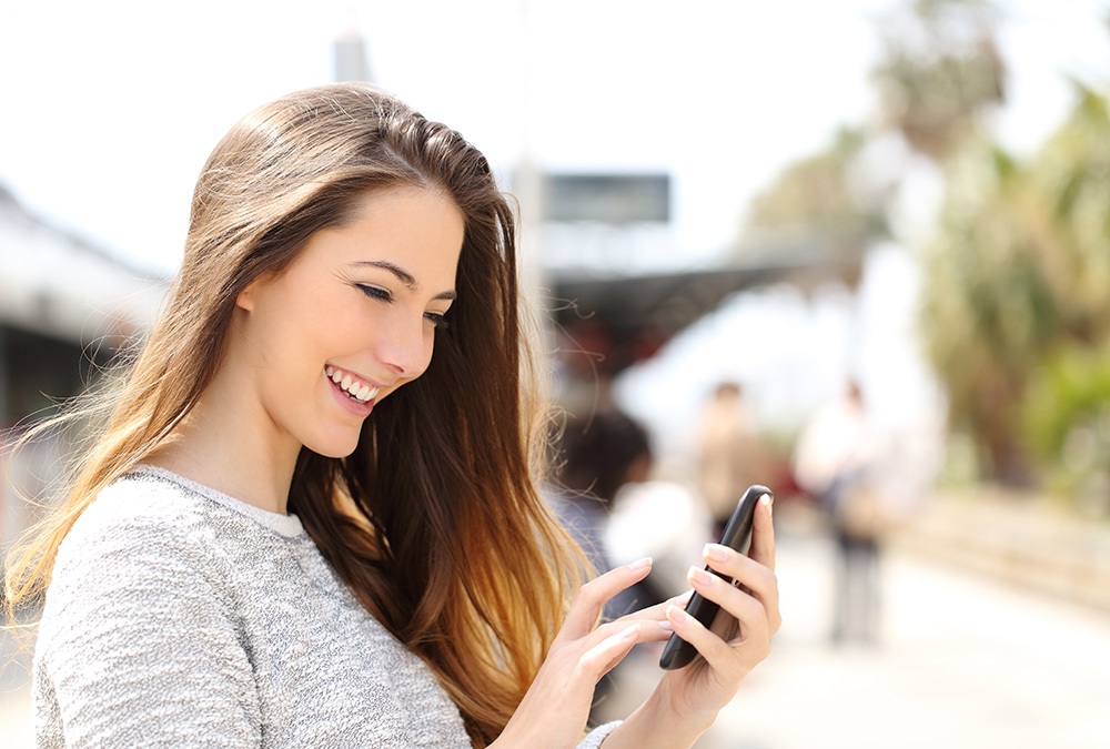 woman smiling after receiving a funny text
