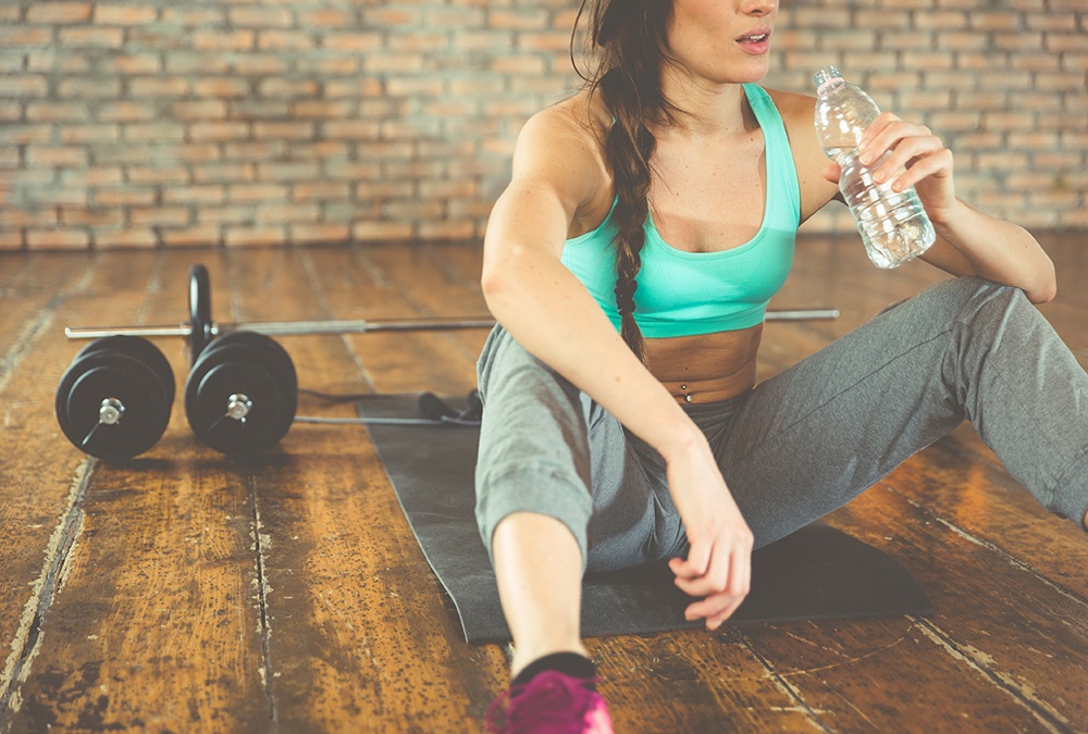 woman drinking water on breakfrom workout