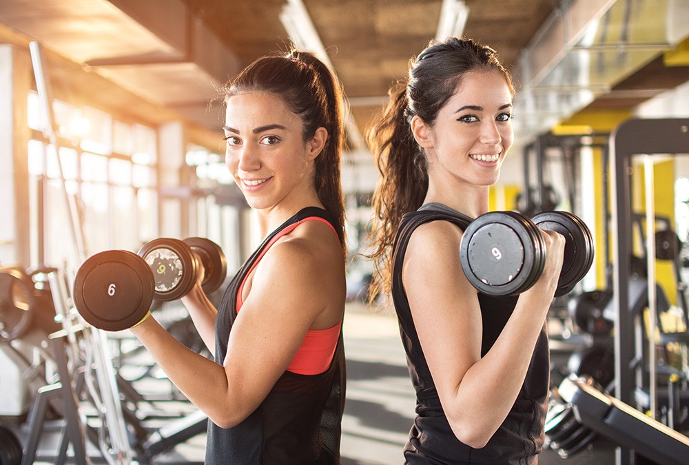 2 women lifting weights