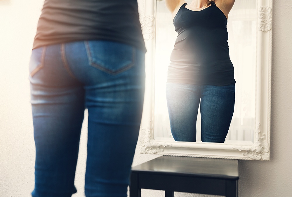 lady looking at mirror with body dysmorphia