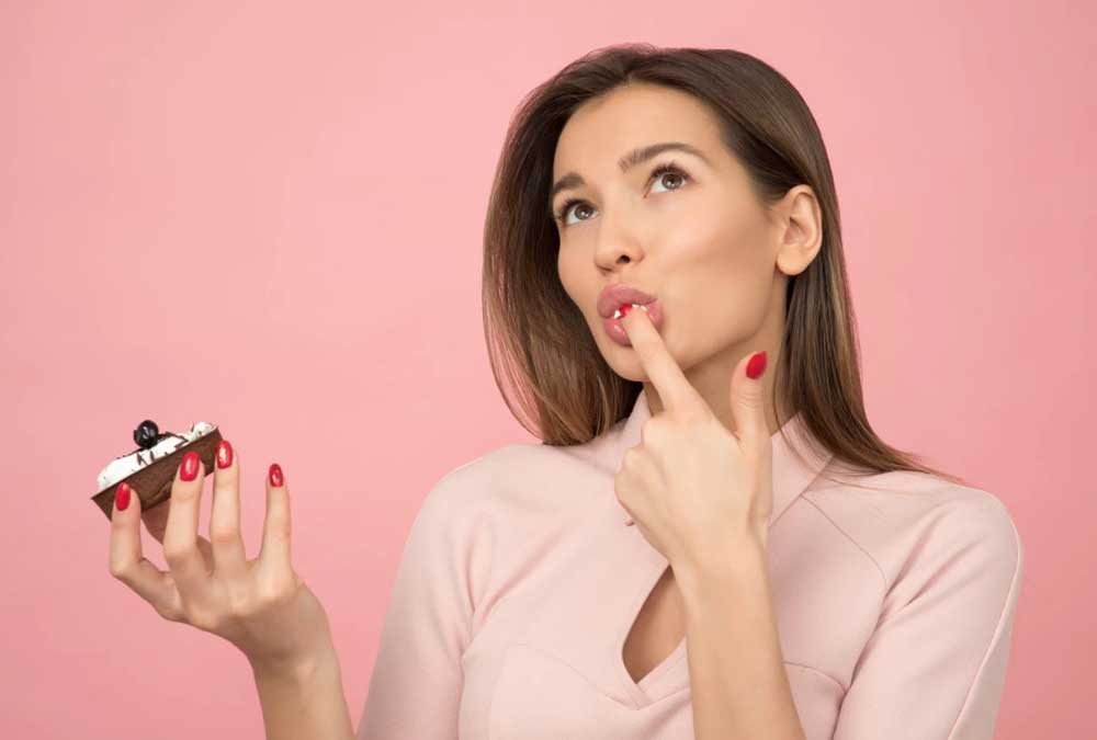 lady tasting cupcake with finger