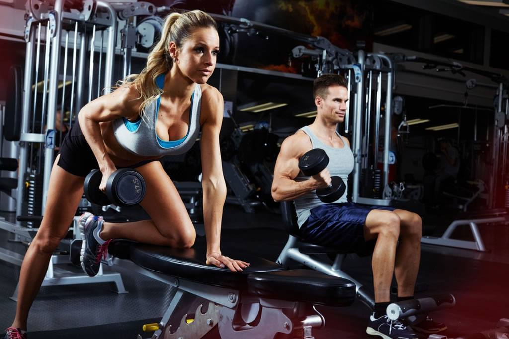 fit couple working out hard in the gym