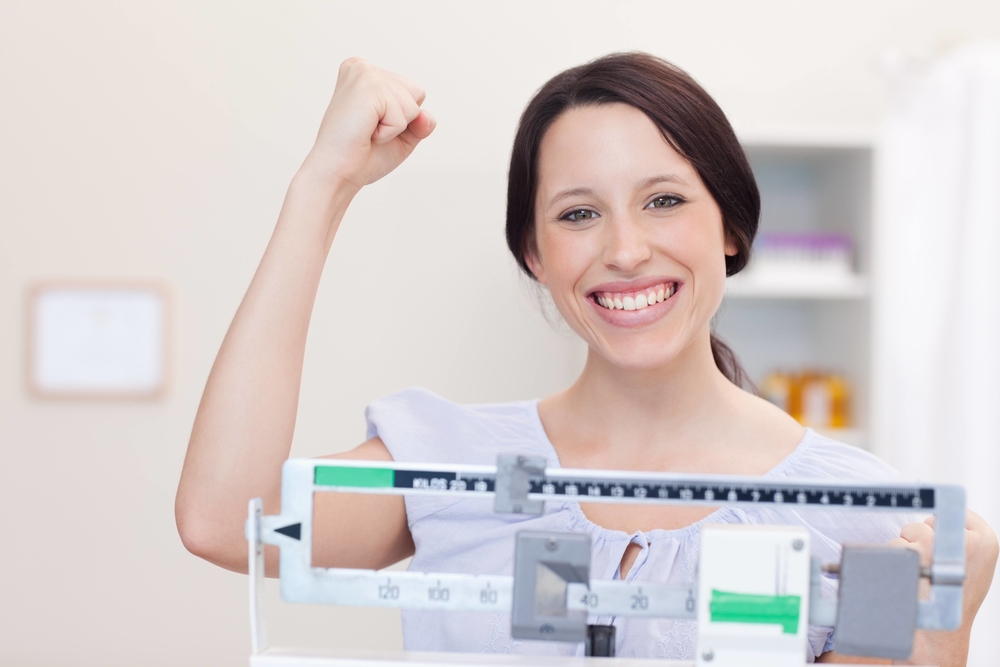 woman with fist in air after reaching weight goals