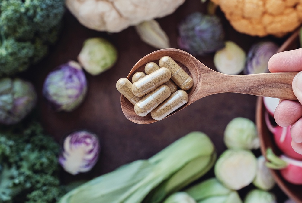 spoonful of keto capsules over vegetables