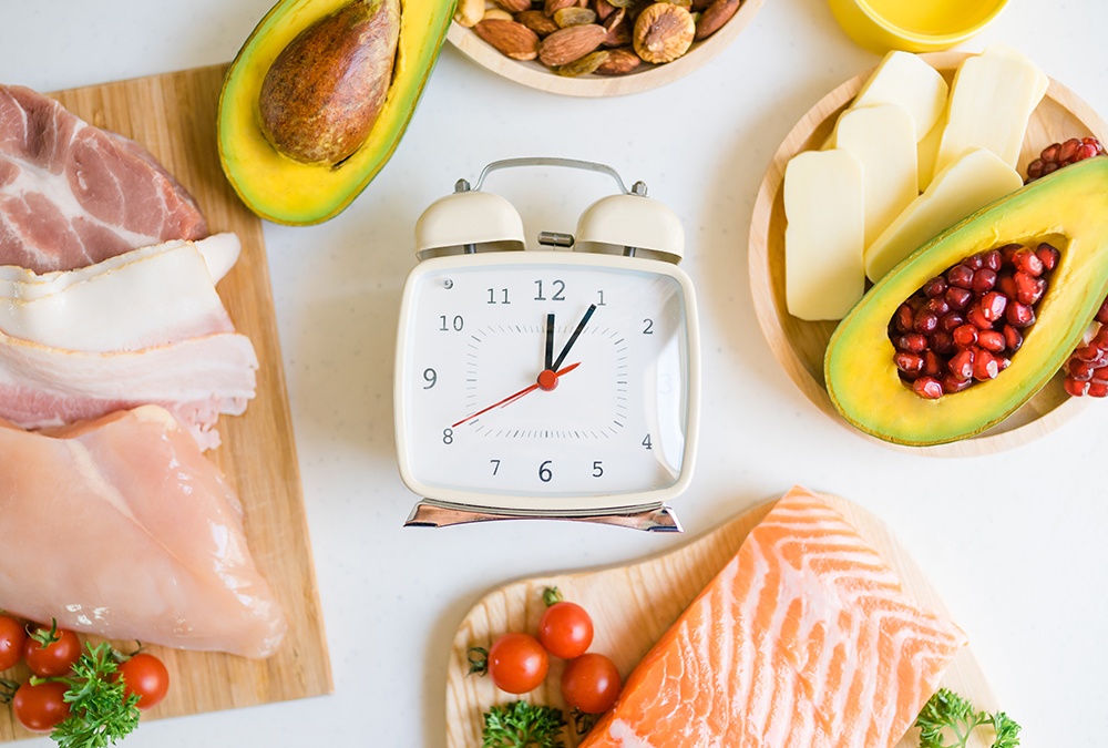 a square clock in the middle of keto friendly foods on the table