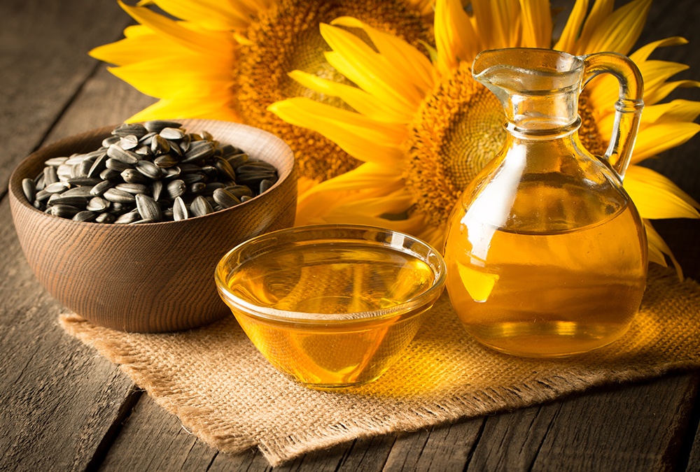 oleic sunflower seeds in a bowl and sunflower oil in a glass jar